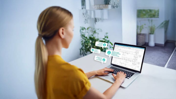 A woman working on a laptop displays a electrical schematics drawing on the screen.