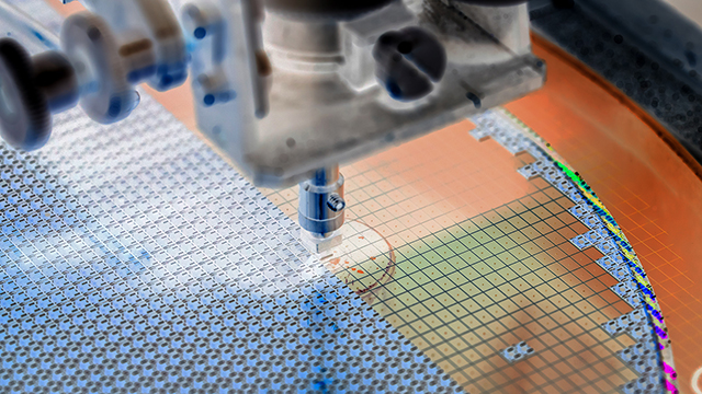 Close-up of a probe or testing needle positioned over a silicon wafer's surface. The wafer shows a copper-colored substrate with grid patterns and testing points, while testing equipment is visible above.