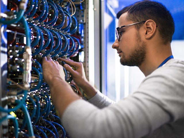 A computer technician working on a multi-connection server.