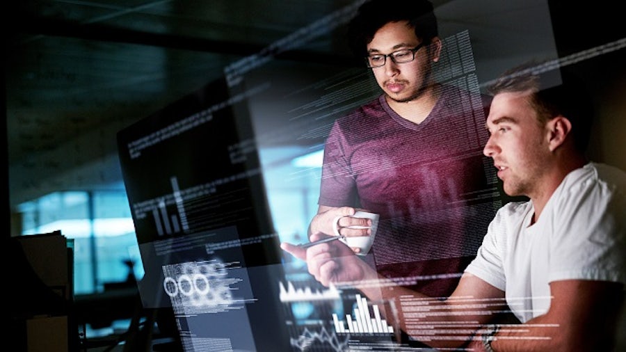 Two knowledge workers collaborating in front of a computer using a low-code platform