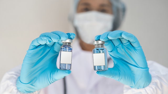 Medical professional holding two vials