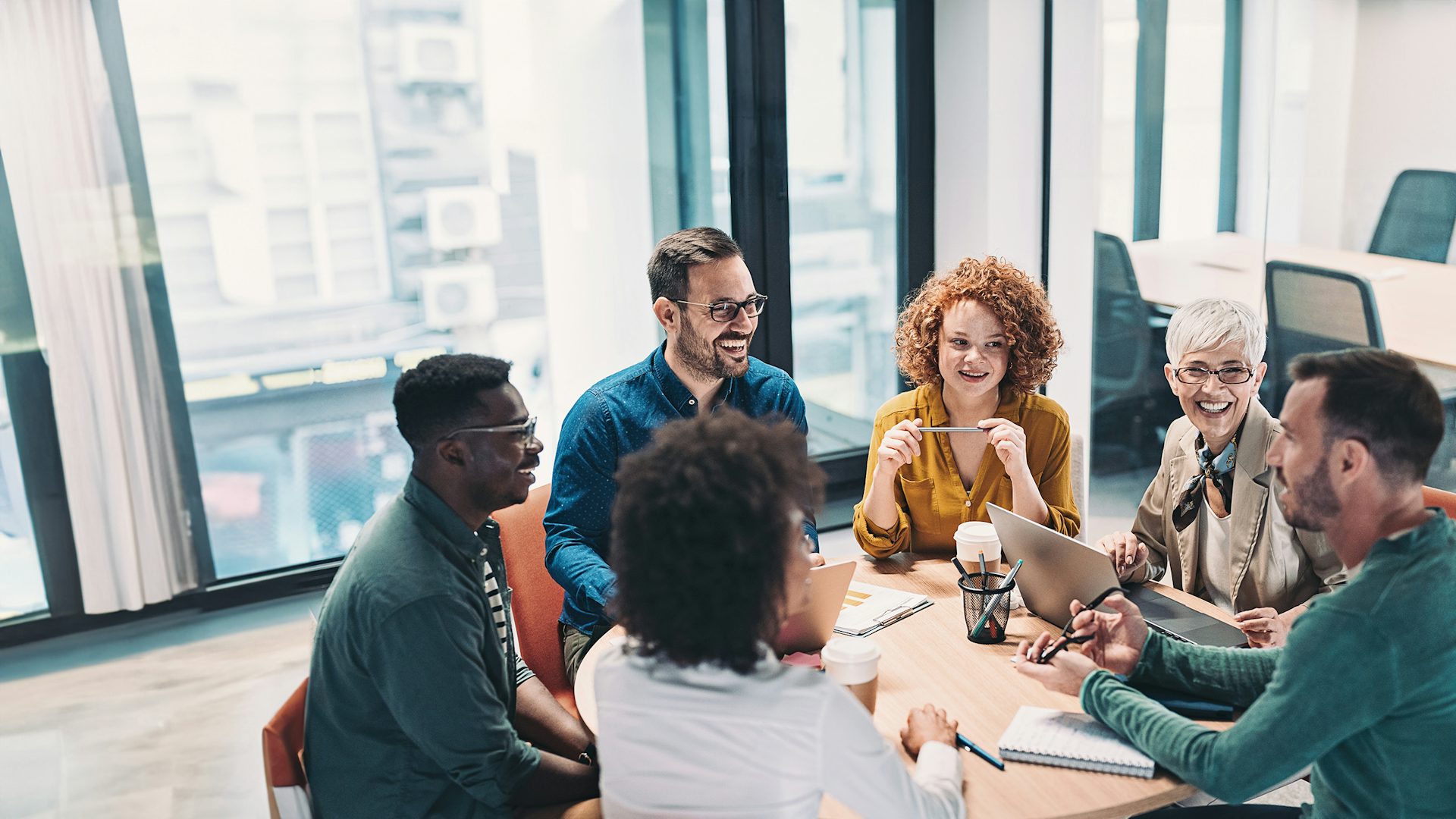 Group of business people sitting at a table having a meeting in an office.