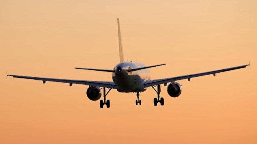 Un avion décollant dans un ciel orangé, sur le point de relever son train d&#39;atterrissage, alimenté par une conception de système électrique complexe et une intégration des faisceaux de câbles.