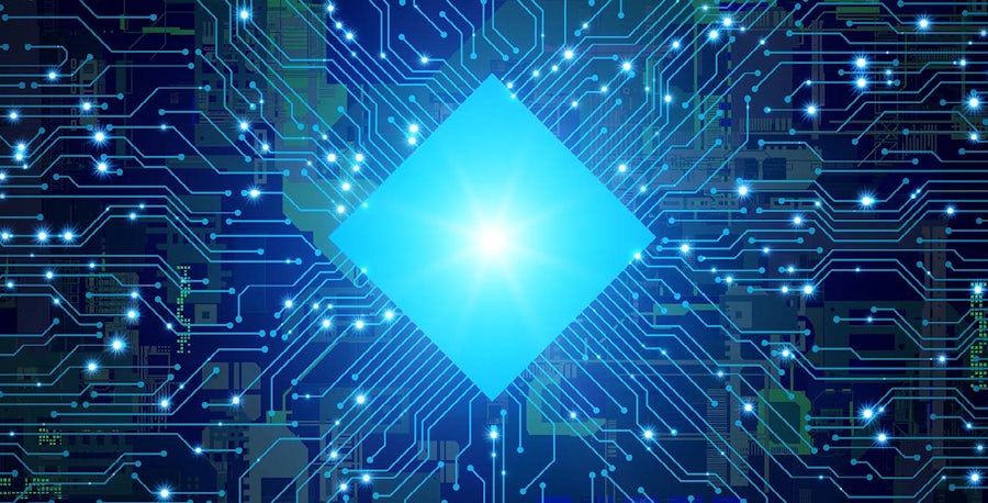 Picture of a glowing, stylized integrated circuit that's glowing white connected to a circuit board with light traces over a blue background