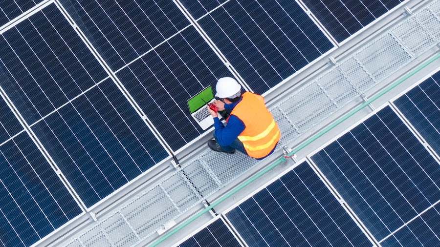 Un uomo con un elmetto seduto su un pannello solare