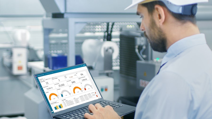 Worker looking at manufacturing intelligence data on a laptop