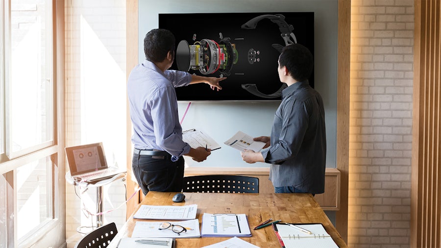 Due ingegneri ispezionano la distinta base di un componente con il software Teamcenter Engineering BOM.