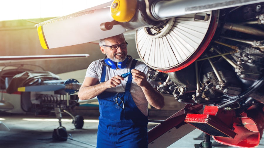 A worker works on an airplane on the factory floor