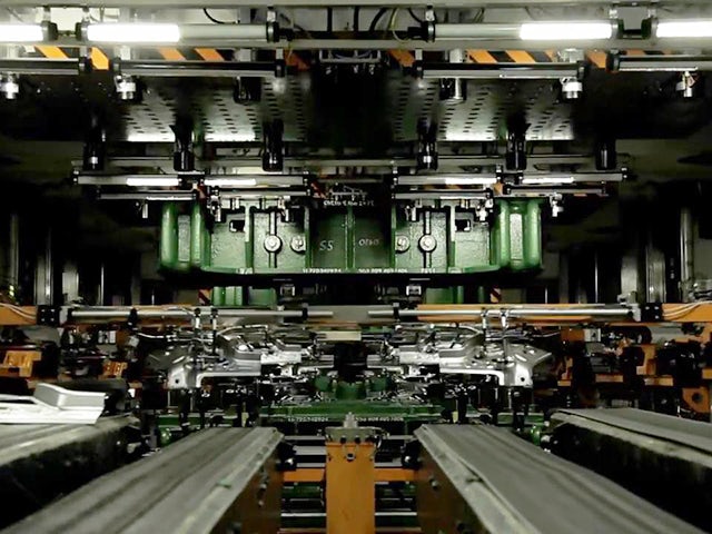 Image of a working stamping press line in a manufacturing facility.