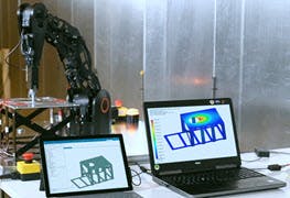 Robot pressing on a metal structure and Simcenter 3D calculating stress and displacement in real-time.