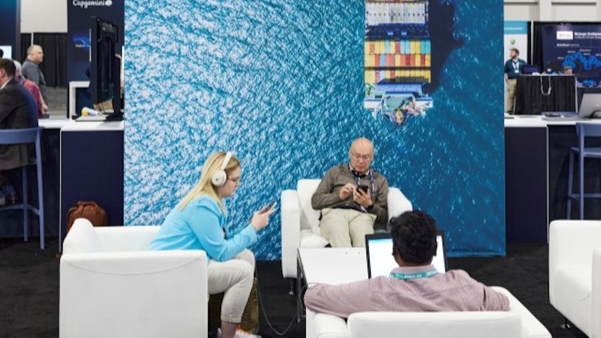 Three individuals sitting in the Siemens Realize LIVE Industry Lounge in the Solutions Center.
