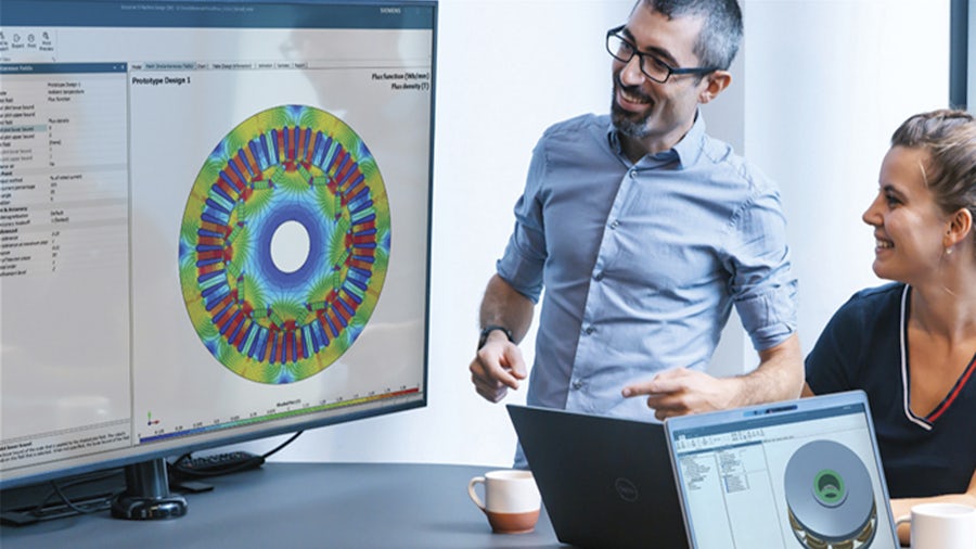 A couple of engineers using the Simcenter E-Machine design software on a big screen.