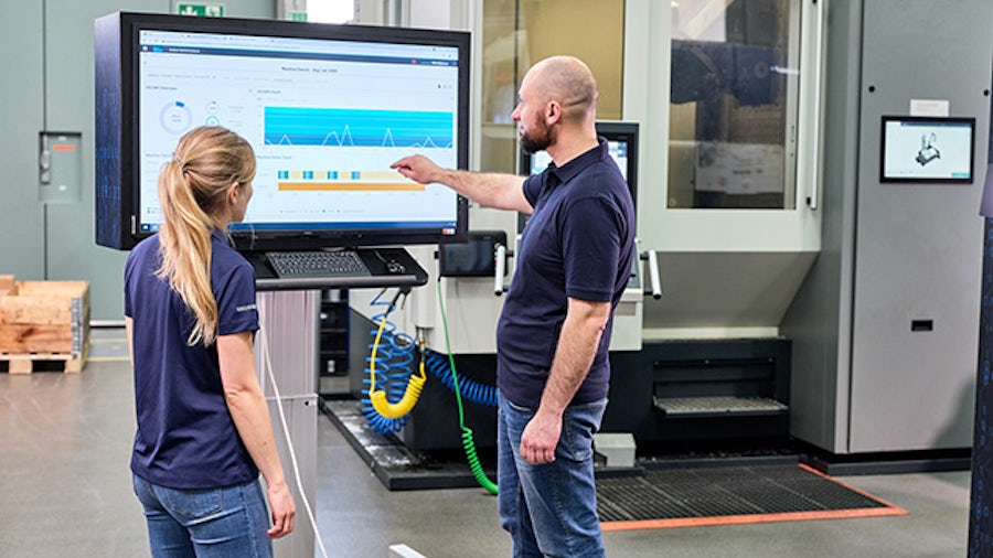 Una donna e un uomo lavorano in un ambiente di produzione CNC