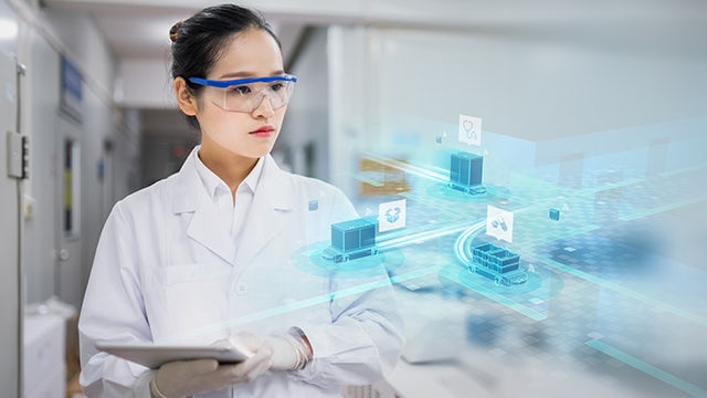 A woman wearing safety glasses visualizes a digital image overlaid inside her laboratory environment.
