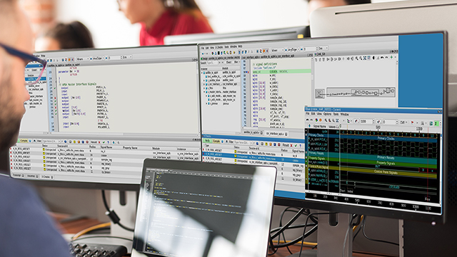 Engineer using Questa Check-X Tool on his laptop and two monitors 