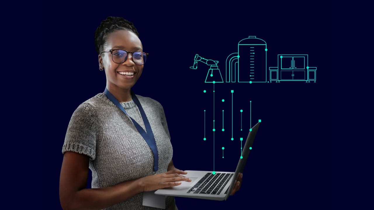 Young woman smiling holding a laptop showing a digital twin of factory elements above the laptop.