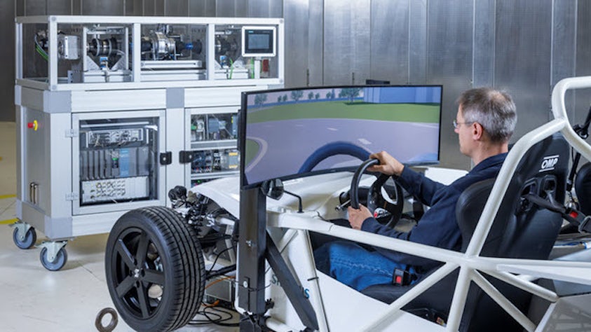 Engineer using an XiL system to test physical electric powertrain in an virtual environment.