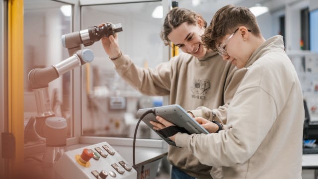 Students working together on a robot arm