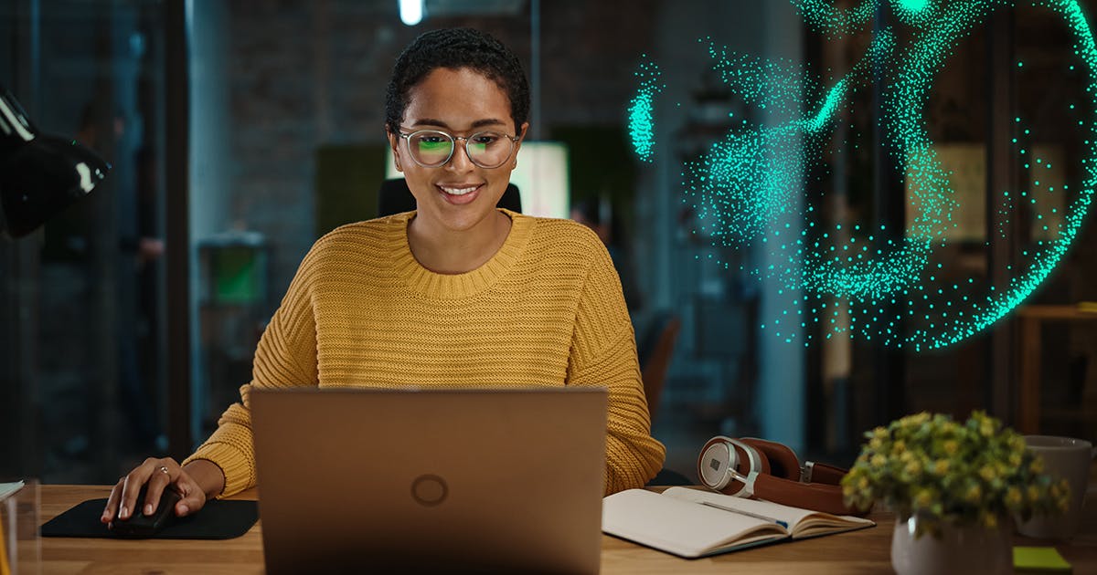 Person bei der Arbeit am Schreibtisch mit Siemens Particle Overlay, das die Leistungsfähigkeit der Cloud-Zusammenarbeit symbolisiert