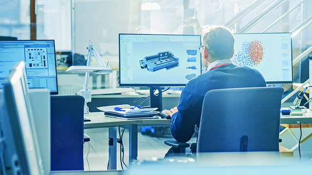 Man sitting at a computer with his back towards the camera