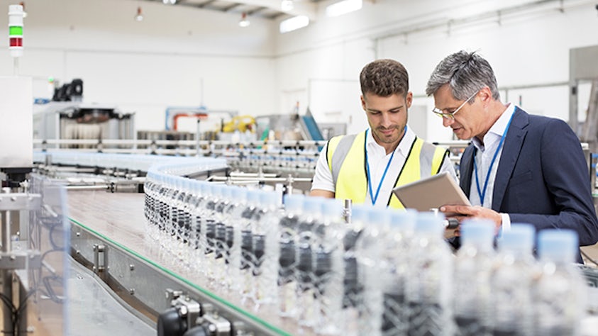 Due operai che utilizzano la produzione di processo in un laboratorio.