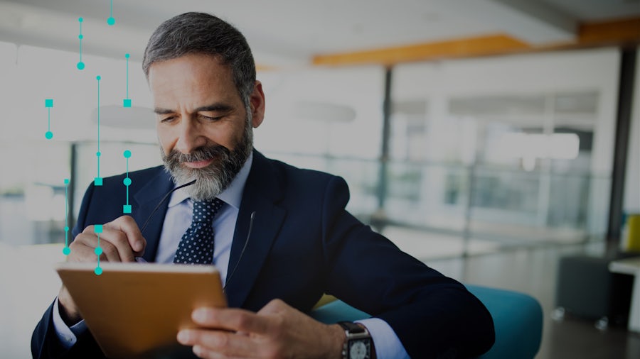 Man wearing a business suit looking at a tablet