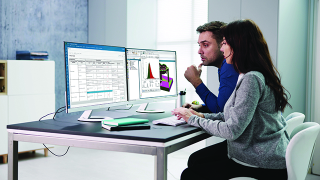 전문가들이 변동 해석을 위해 품질 관리 소프트웨어를 사용하고 있으며, 대형 모니터에 그래프와 데이터 스프레드시트가 표시되어 있습니다.