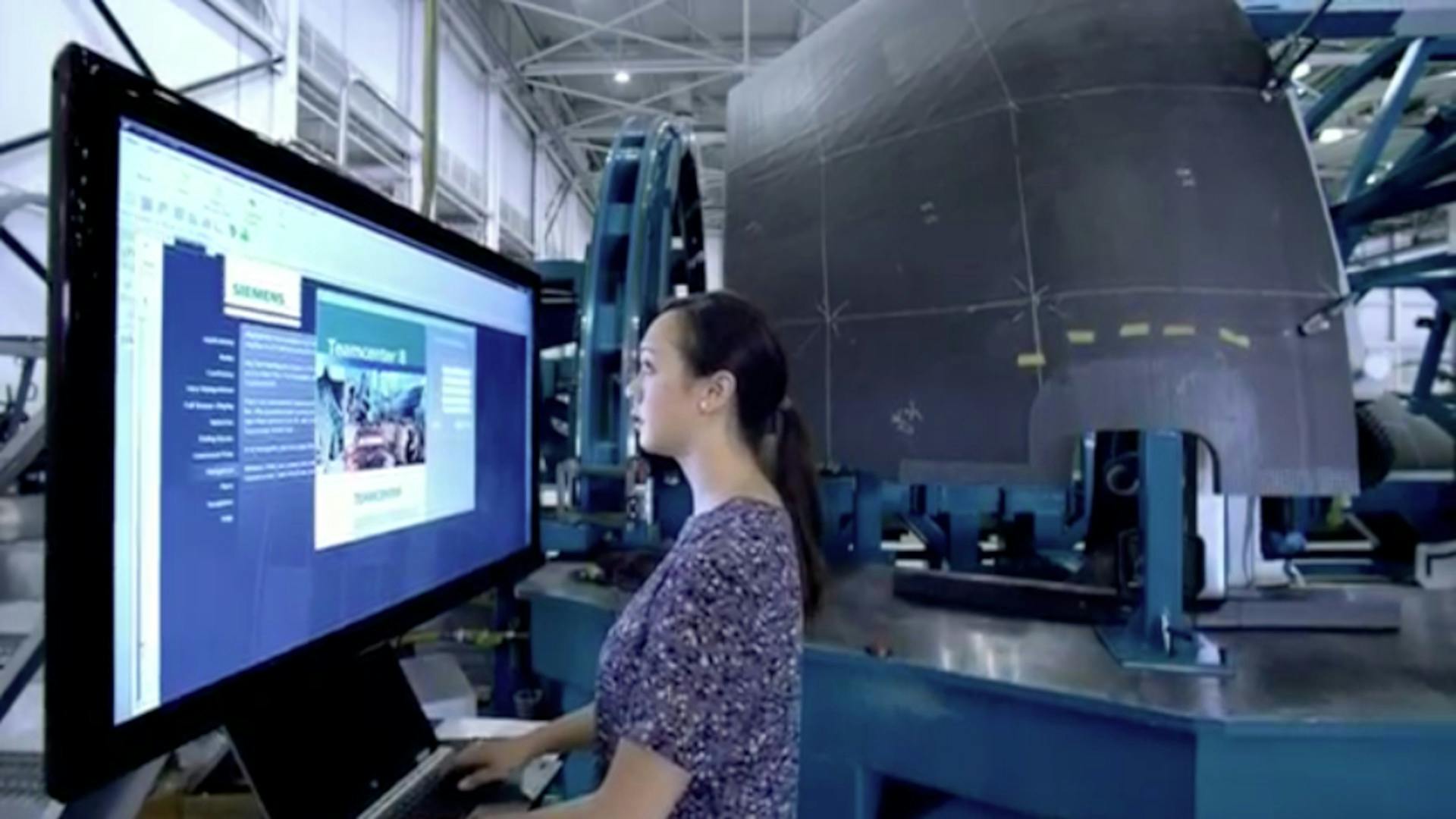 An engineer on a high-tech robotic line for the production of aerospace engines controls information using a modern innovative graphical interface.